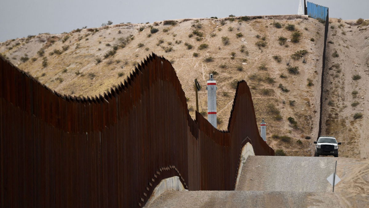<i>Patrick T. Fallon/AFP/Getty Images</i><br/>A US Border Patrol vehicle sits next to a border wall in the El Paso Sector along the US-Mexico border between New Mexico and Chihuahua state on December 9