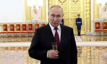 President Putin is pictured at the Kremlin reception while clutching a glass of champagne.