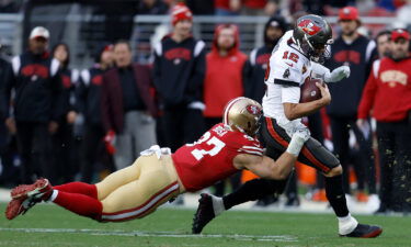 Tampa Bay Buccaneers quarterback Tom Brady runs against San Francisco 49ers defensive end Nick Bosa during the second half of their game.