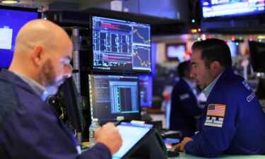 Traders work on the floor of the New York Stock Exchange during morning trading on December 6. Stocks sank Tuesday