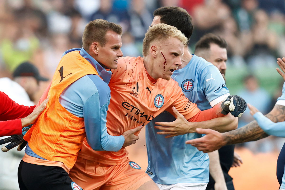 <i>Darrian Traynor/Getty Images</i><br/>Tom Glover of Melbourne City is escorted from the pitch by teammates after fans stormed the pitch during the game against Melbourne Victory.