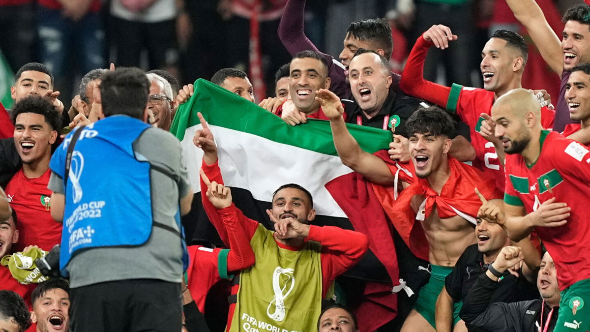 <i>Martin Meissner/AP</i><br/>Morocco's team poses with the Palestinian flag after beating Spain on December 6.