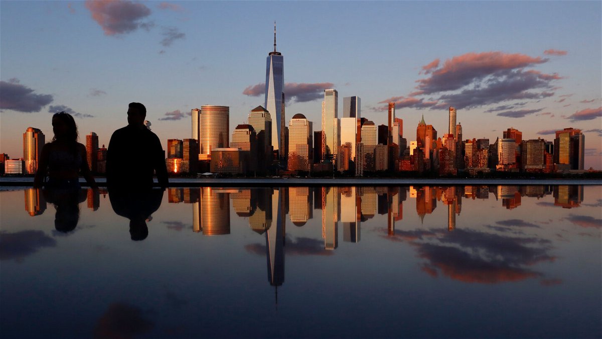 <i>Gary Hershorn/Getty Images</i><br/>The skyline of lower Manhattan and One World Trade Center is reflected in the top of a monument as the sun sets in New York City on June 19