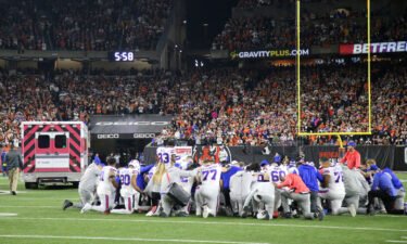 Buffalo Bills players kneel to pray as the ambulance carrying teammate Buffalo Bills safety Damar Hamlin (not pictured) leaves the playing field during the first quarter against the Cincinnati Bengals at Paycor Stadium.