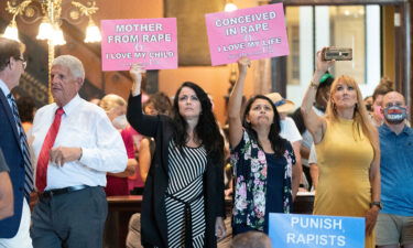 Protesters hold signs inside the South Carolina Statehouse as lawmakers debate an abortion ban in August