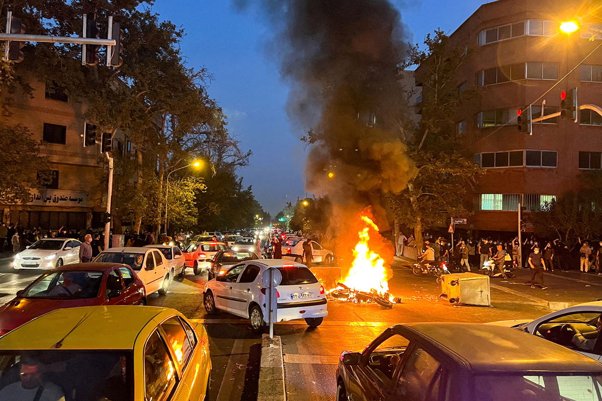 <i>Wana News Agency/Reuters</i><br/>A police motorcycle burns during a protest over the death of Mahsa Amini