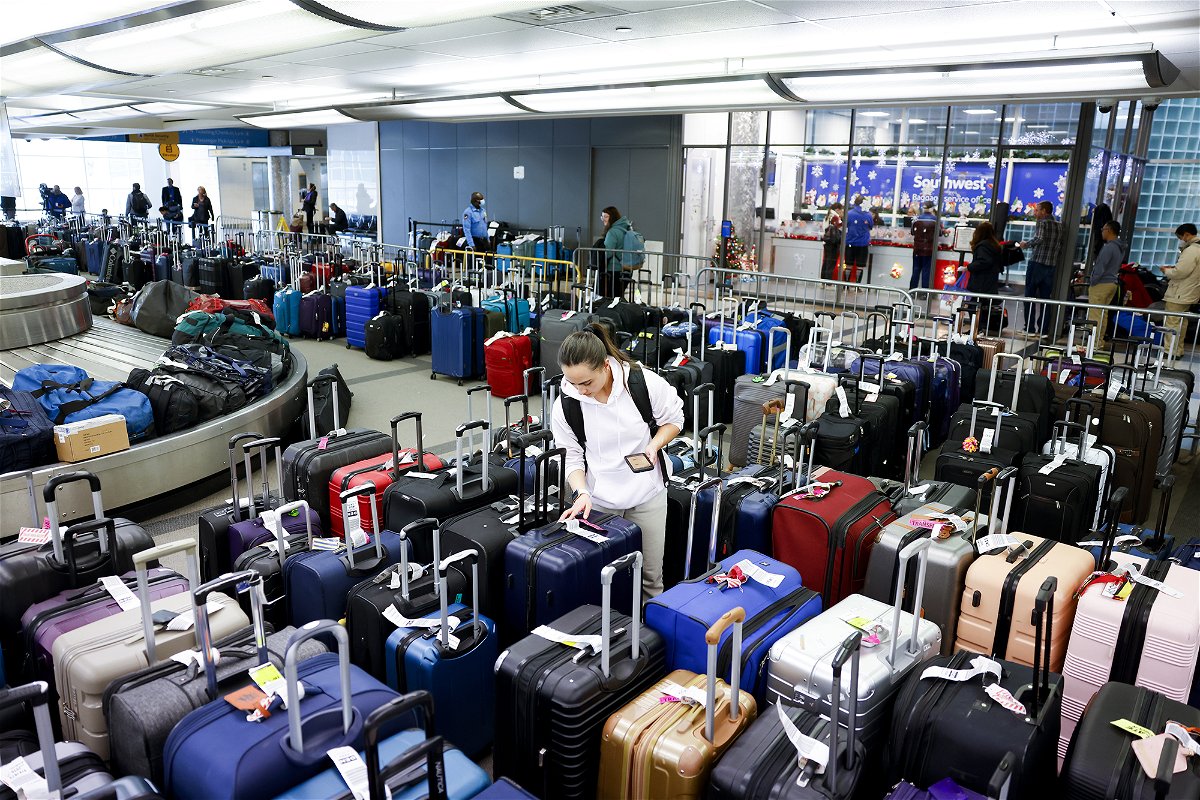 <i>Michael Ciaglo/Getty Images</i><br/>A traveler searches for a friend's suitcase in a baggage holding area for Southwest Airlines at Denver International Airport on December 28