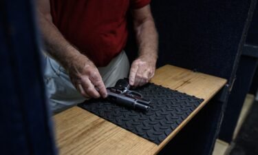 Shooting range owner John Deloca prepares his pistol at his range in Queens