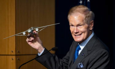 NASA Administrator Bill Nelson holds a model of an aircraft with a Transonic Truss-Braced Wing.