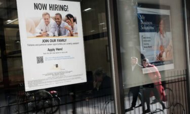 Weekly jobless claims fell to the lowest level since September. A 'now hiring' sign is displayed in the window of a store in Manhattan on December 02