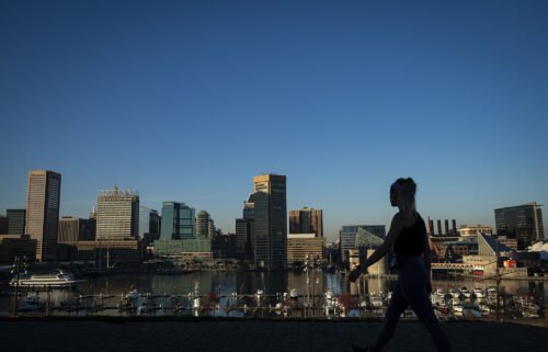 A pedestrian walks past the downtown Baltimore skyline in Federal Hill Park in November of 2020.