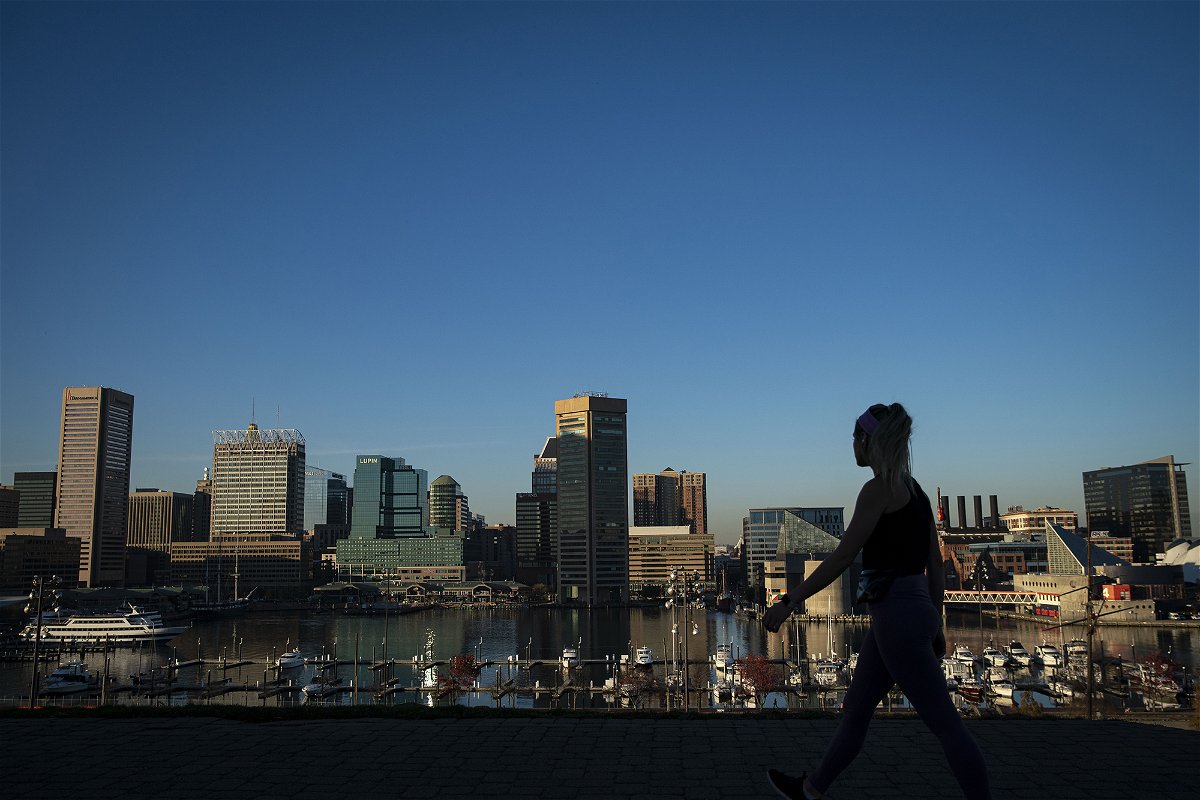 <i>Al Drago/Bloomberg/Getty Images</i><br/>A pedestrian walks past the downtown Baltimore skyline in Federal Hill Park in November of 2020.
