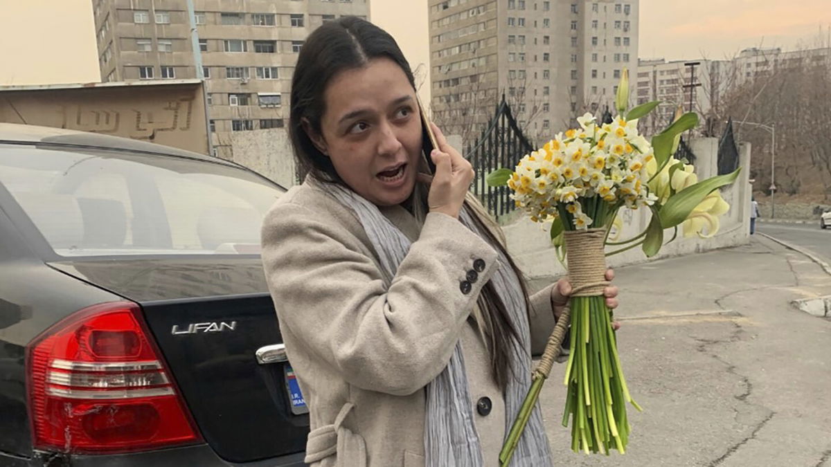 <i>Gisoo Faghfouri/AP</i><br/>Iranian prominent actress Taraneh Alidoosti speaks on a cellphone as she holds bunches of flowers after being released from Evin prison in Tehran