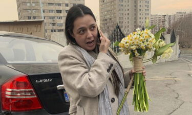 Iranian prominent actress Taraneh Alidoosti speaks on a cellphone as she holds bunches of flowers after being released from Evin prison in Tehran