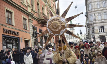 Ukrainians sing Christmas carols as they carry decorated stars of Bethlehem and sheaves of wheat in their hands during a festive parade in Lviv on January 6
