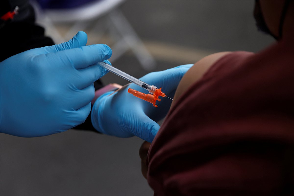 <i>Shannon Stapleton/Reuters</i><br/>A health care administer gives the second dose of the Pfizer-BioNTech coronavirus disease vaccine to a person at the L.A.