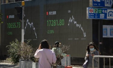 A public screen displays the Shenzhen Stock Exchange and the Hang Seng Index figures in Shanghai