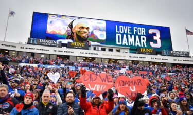Fans stand in support for Buffalo Bills safety Damar Hamlin before an NFL football game against the New England Patriots on Sunday.