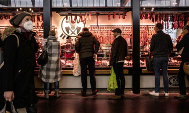 Inflation in Europe continued to decline in December as energy prices rose at a slower pace. Customers are pictured waiting to buy products from a meat vendor in Frankfurt