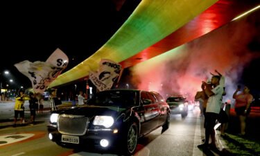The hearse carrying Pele's coffin arrives into Santos as a firework goes off in the early morning ahead of the wake.