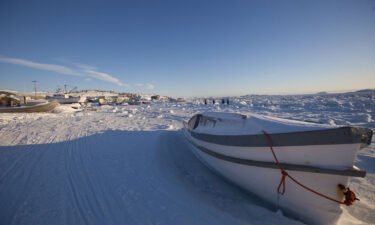 A boat sits along the frozen shoreline in Iqaluit