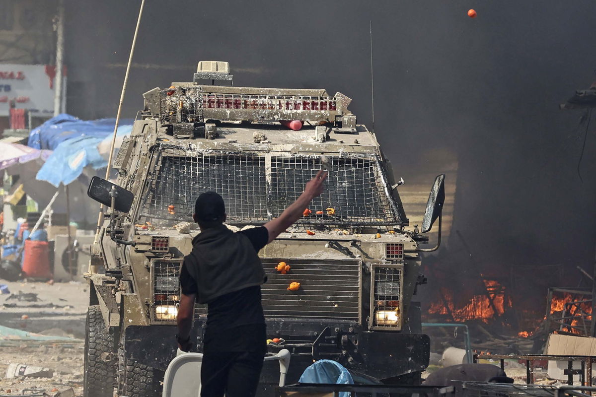 <i>Zain Jaafar/AFP/Getty Images</i><br/>A Palestinian faces an Israeli military vehicle during a raid on the West Bank city of Nablus