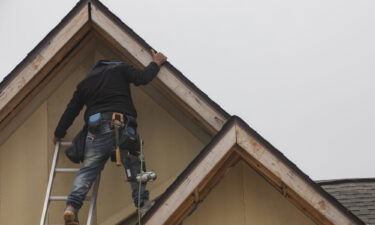 New home sales rose in January from December. Pictured is a construction worker working on a new home in Foley