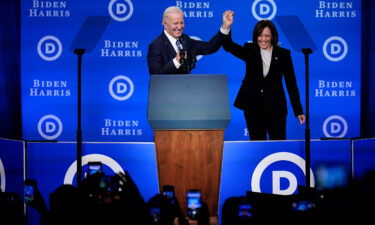 President Joe Biden (left) and Vice President Kamala Harris hold their hands up at the Democratic National Committee winter meeting on February 3 in Philadelphia.