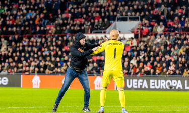 A pitch invader aimed a punch at Sevilla goalkeeper Marko Dmitrović during the game against PSV.