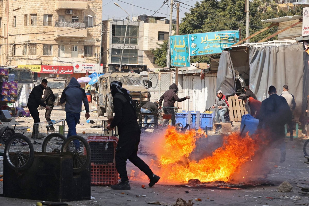 <i>Zain Jaafar/AFP/Getty Images</i><br/>Palestinians clash with Israeli forces amid a raid in the West Bank city of Nablus