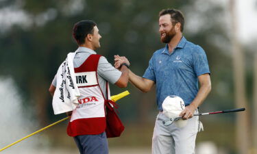 Kirk is congratulated by his caddie after victory.
