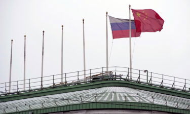 The flags of Russia and China flutter on the roof of a hotel in central St. Petersburg