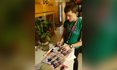 Kelly signing pictures from the Olympics for fans in the family home in Arden Hills