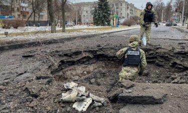 Police officers inspect a crater near the site of a damaged residential building on February 2 amid Russia's repeated attacks on Kramatorsk.