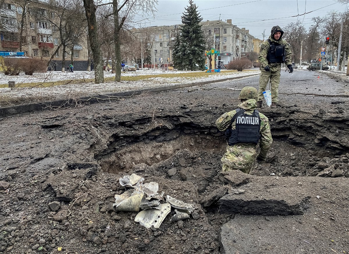 <i>Vitalii Hnidyi/Reuters</i><br/>Police officers inspect a crater near the site of a damaged residential building on February 2 amid Russia's repeated attacks on Kramatorsk.