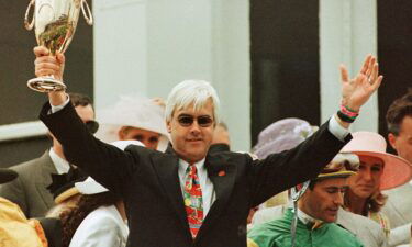 Trainer Bob Baffert holds up the Kentucky Derby Trophy to celebrate the win of Silver Charm at the 123rd Kentucky Derby at Churchill Downs in Louisville in May 1997. Silver Charm won in a photo finish over Captain Bodgit. Next to Baffert is winning jockey Gary Stevens (R).