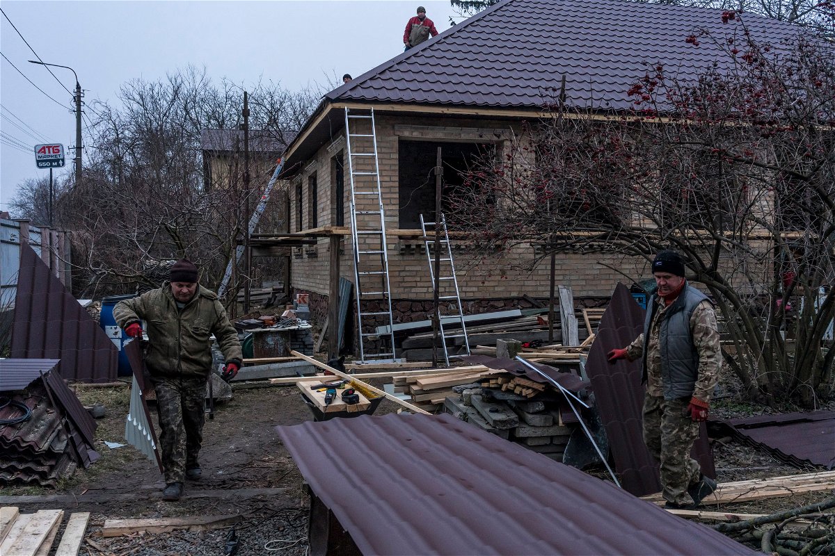 <i>Brendan Hoffman for CNN</i><br/>Workers cut pieces of roofing as they repair the house belonging to Kostiantyn Momotov