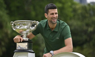 Novak Djokovic holds the Norman Brookes Challenge Cup trophy following his Australian Open victory.