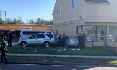 Investigators examine a vehicle after it crashed into the side of a building in Winter Haven