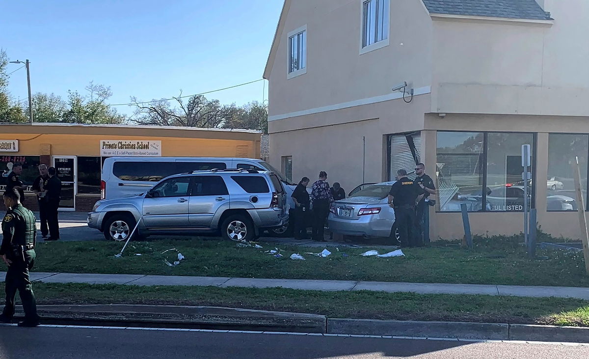 <i>Sara Megan Walsh/The Ledger/AP</i><br/>Investigators examine a vehicle after it crashed into the side of a building in Winter Haven