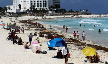 Tourists enjoy the beach despite the sargassum algae buildup in Cancun