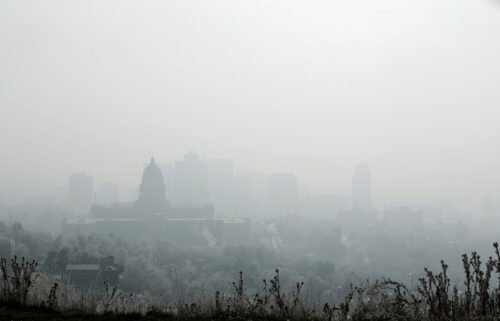 The Utah State Capitol (L) and buildings are shrouded in smog in downtown Salt Lake City