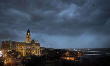 Debris flies through the air as howling winds accompanied by a line of storms approach the old Tarrant County Courthouse in downtown Fort Worth