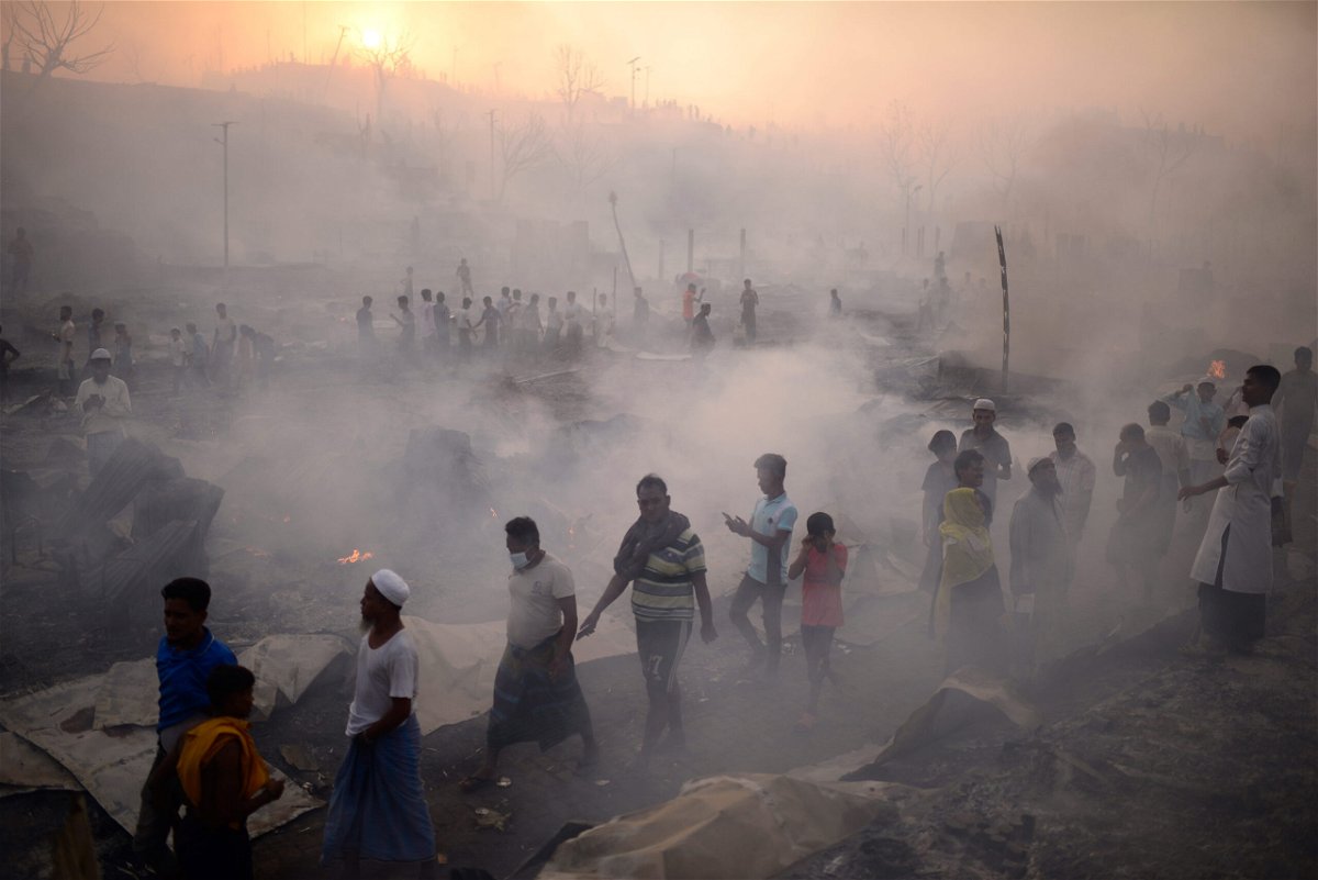 <i>Mahmud Hossain Opu/AP</i><br/>Rohingya refugees try to salvage their belongings after the major fire ripped through the camp.