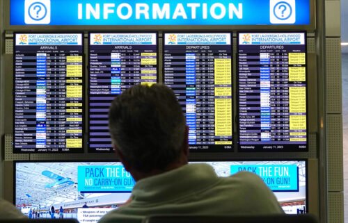 A man looks at the flight information board at Fort Lauderdale-Hollywood International Airport after an early morning FAA system outage caused delays across the country in January. Such incidents are making some people think twice before booking flights.