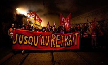 Railway workers hold a banner reading "Until the withdrawal" during a demonstration a few days after the government forced the pension reform through parliament without a vote.