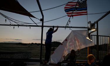 Brooke Wyatt and Michael Scileppi take down a Tina Peters banner after a watch party for her unsuccessful bid to win the Republican candidacy for secretary of state on June 28