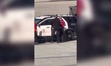 A  passenger is taken into custody after opening a door of a Boeing 737 and deploying an emergency exit slide Sunday at Los Angeles International Airport.