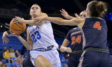 Gabriela Jaquez is fouled by Aixchel Hernandez as she drives past Kathryn Neff and Gabi Vidmar of the CSU Fullerton Titans on December 10