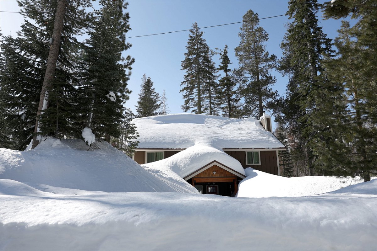 <i>Justin Sullivan/Getty Images</i><br/>A home is seen buried in snow on March 3 in Twin Bridges
